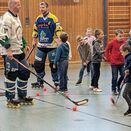 Den Schülern wird in der Turnhalle Indoorhockey vorgestellt